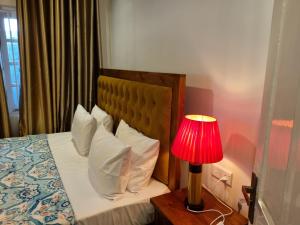 a bedroom with a bed with a red lamp at Astoria Cottage in Nuwara Eliya +51 photos