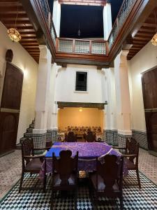 een eetkamer met een paarse tafel en stoelen bij Riad Ranya in Fès