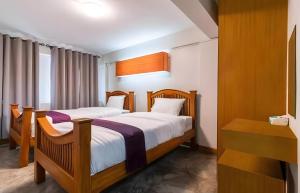 une chambre avec deux lits et une fenêtre dans l'établissement GO INN Khaosan Bangkok - ถนนข้าวสาร กรุงเทพมหานคร, à Bang Bua Thong Railway Station