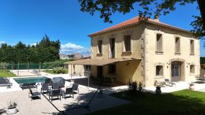 un bâtiment avec une piscine et un patio dans l'établissement Bastide des Oliviers, Maison Provençale, à Boulbon