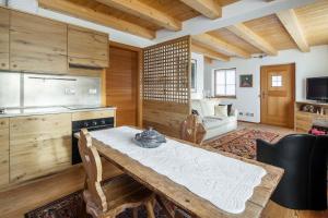 a kitchen with a wooden table and a dining room at Chalet Lacedel - Dolomiti Skyline in Cortina dʼAmpezzo