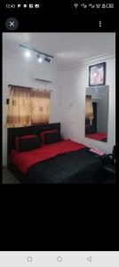 een slaapkamer met een groot bed met een rode deken bij Short Let Apartments in Lagos Business School Lekki Ajah in Lekki