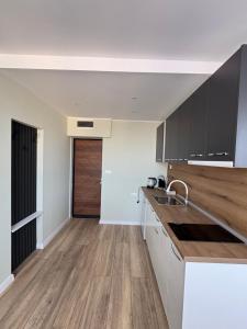 a kitchen with white cabinets and a wooden floor at Atelier SkyLine in Gabrovo +3 photos