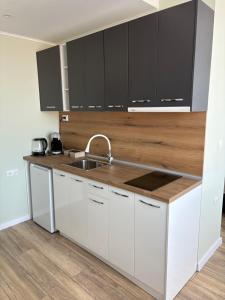 a kitchen with white cabinets and a sink at Atelier SkyLine in Gabrovo