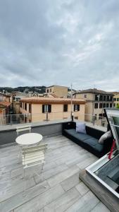 a balcony with a table and a couch on a roof at Frascati Tower B&B in Frascati