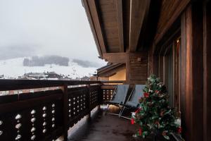ein Weihnachtsbaum auf dem Balkon einer Hütte in der Unterkunft Chalet Layla by Original Galli in Livigno + 54 Fotos