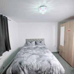 a bedroom with a bed and a ceiling fan at Ellas Stays in Farnworth