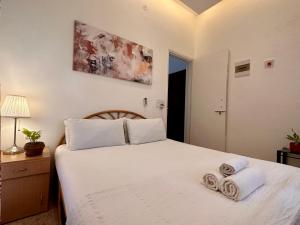 比纳里姆VOLTA By the Beach Goa的卧室里有一张白色的床，床上放着毛巾 更多73张照片