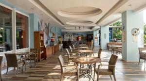 a restaurant with tables and chairs in a room at Pine House by Werde Hotels in Kemer