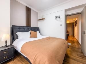 een slaapkamer met een groot bed met een zwart hoofdeinde bij Annie Apartment 3206 in Kunming