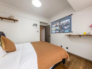 een slaapkamer met een bed en een groot scherm aan de muur bij Annie Apartment 3206 in Kunming +1 foto