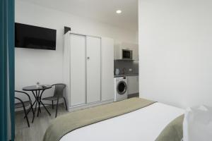 een slaapkamer met een bed en een tafel en een keuken bij Residência Lord Freitas I by An Island Apart in Funchal