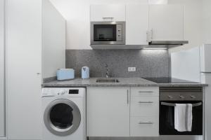 een keuken met een wasmachine en een magnetron bij Residência Lord Freitas I by An Island Apart in Funchal