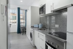 een witte keuken met een spoelbak en een vaatwasser bij Residência Lord Freitas I by An Island Apart in Funchal