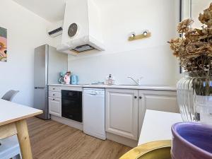 a kitchen with white cabinets and a black dishwasher at Studio en Provence in Cheval-Blanc +5 photos