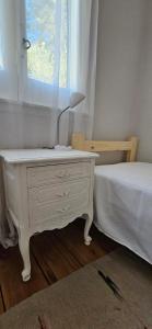een witte ladekast met een lamp naast een bed bij casamila in San Javier