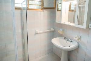 een witte badkamer met een wastafel en een douche bij Numana, casa singola vista mare a 100mt dalla spiaggia in Numana