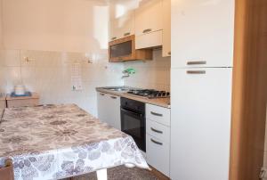 een kleine keuken met een witte koelkast en een tafel bij Numana, casa singola vista mare a 100mt dalla spiaggia in Numana +18 foto's