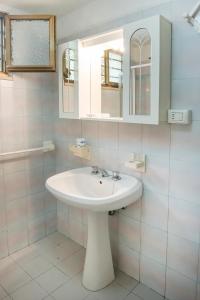 een witte badkamer met een wastafel en een spiegel bij Numana, casa singola vista mare a 100mt dalla spiaggia in Numana