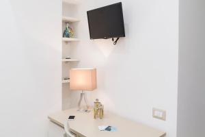 a table with a lamp and a tv on a wall at Il Vicoletto in Amalfi +55 photos