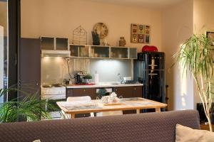 eine Küche mit einem Tisch und eine Küche mit einer Theke in der Unterkunft Urban Flat 2026 - At Central Square - Pet Friendly in Kavala + 17 Fotos