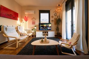 ein Wohnzimmer mit Stühlen und einem Couchtisch in der Unterkunft Urban Flat 2026 - At Central Square - Pet Friendly in Kavala