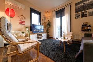 a living room with a chair and a tv at Urban Flat 2026 - At Central Square - Pet Friendly in Kavala