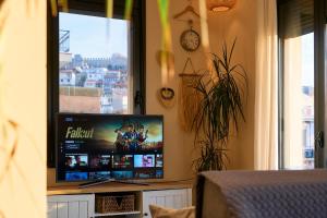 einen Flachbild-TV in einem Zimmer mit Fenster in der Unterkunft Urban Flat 2026 - At Central Square - Pet Friendly in Kavala