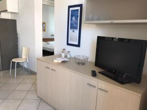 un salon avec une télévision à écran plat sur une armoire dans l'établissement Residenza Viel, à Bibione