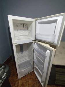 een lege koelkast met de deur open in een keuken bij Studio Apartamento in Capão da Canoa +4 foto's