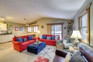 a living room with red couches and blue chairs at Crystal Mountain Resort Cabin: Golf, Hike, Swim! in Thompsonville
