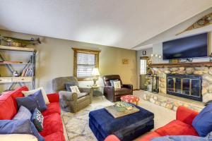a living room with a red couch and a fireplace at Crystal Mountain Resort Cabin: Golf, Hike, Swim! in Thompsonville
