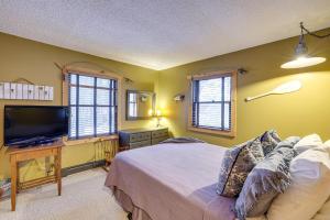 a bedroom with a bed and a flat screen tv at Crystal Mountain Resort Cabin: Golf, Hike, Swim! in Thompsonville