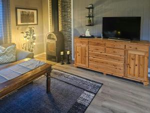 una sala de estar con un gran centro de entretenimiento con TV de pantalla plana en Charming Farm Stay On Averøy Island, en Lyngstad