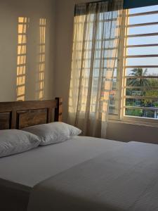 een slaapkamer met een wit bed met een raam bij Ocean breeze in Galle