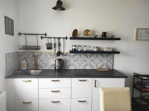 a kitchen with white cabinets and a black counter top at Golden Home Törökbálint in Törökbálint