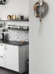 a kitchen with white cabinets and a wreath on the wall at Golden Home Törökbálint in Törökbálint +6 photos