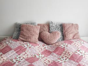 a bed with a quilt and two pillows on it at Golden Home Törökbálint in Törökbálint
