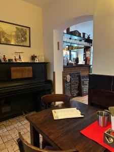 een eetkamer met een tafel en een piano bij Penzion Stará škola Klíny in Klíny +9 foto's