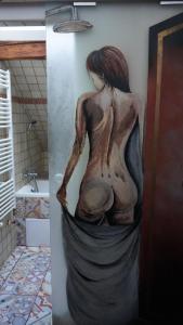 een standbeeld van een vrouw aan een muur in een badkamer bij Penzion Stará škola Klíny in Klíny