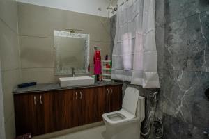 een badkamer met een wastafel, een toilet en een spiegel bij The Heritage in Jodhpur