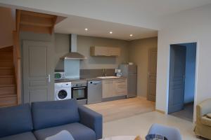 un soggiorno con divano blu in cucina di Gite Clémentine a Baromesnil