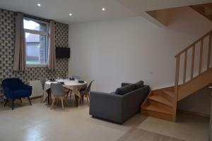 una sala da pranzo con un tavolo e sedie blu di Gite Clémentine a Baromesnil