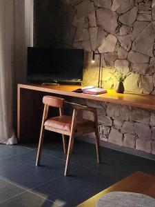 a wooden desk with a computer and a chair at Boutique Hotel Bodega CICLO ANDINO in Perdriel