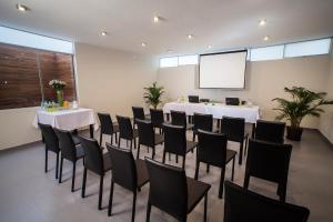 a conference room with tables and chairs and a screen at El Angolo in Lima