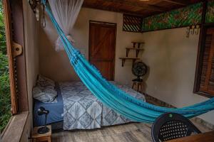 a bed with a hammock in a room at Bangalôs Suítes na Floresta Encantada in Santarém