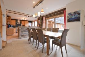 una cucina e una sala da pranzo con tavolo e sedie in legno di Chalet La Hulotte a Brides-les-Bains