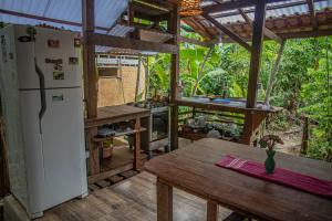 a kitchen with a refrigerator and a wooden table at Bangalôs Suítes na Floresta Encantada in Santarém