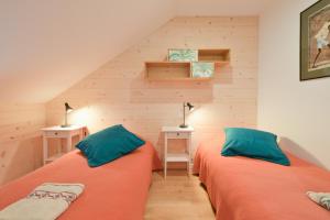 due letti in una piccola stanza con due lampade di Chalet La Hulotte a Brides-les-Bains