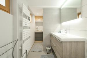 un bagno bianco con lavandino e specchio di Chalet La Hulotte a Brides-les-Bains Altre 32 foto